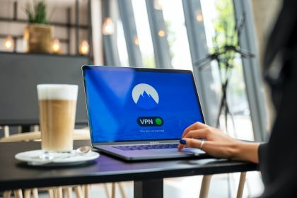 Eine Frau nutzt einen Laptop, auf dem ein VPN-Symbol zu erkennen ist.